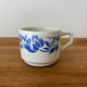 Set of 2 antique earthenware cups with blue floral pattern.