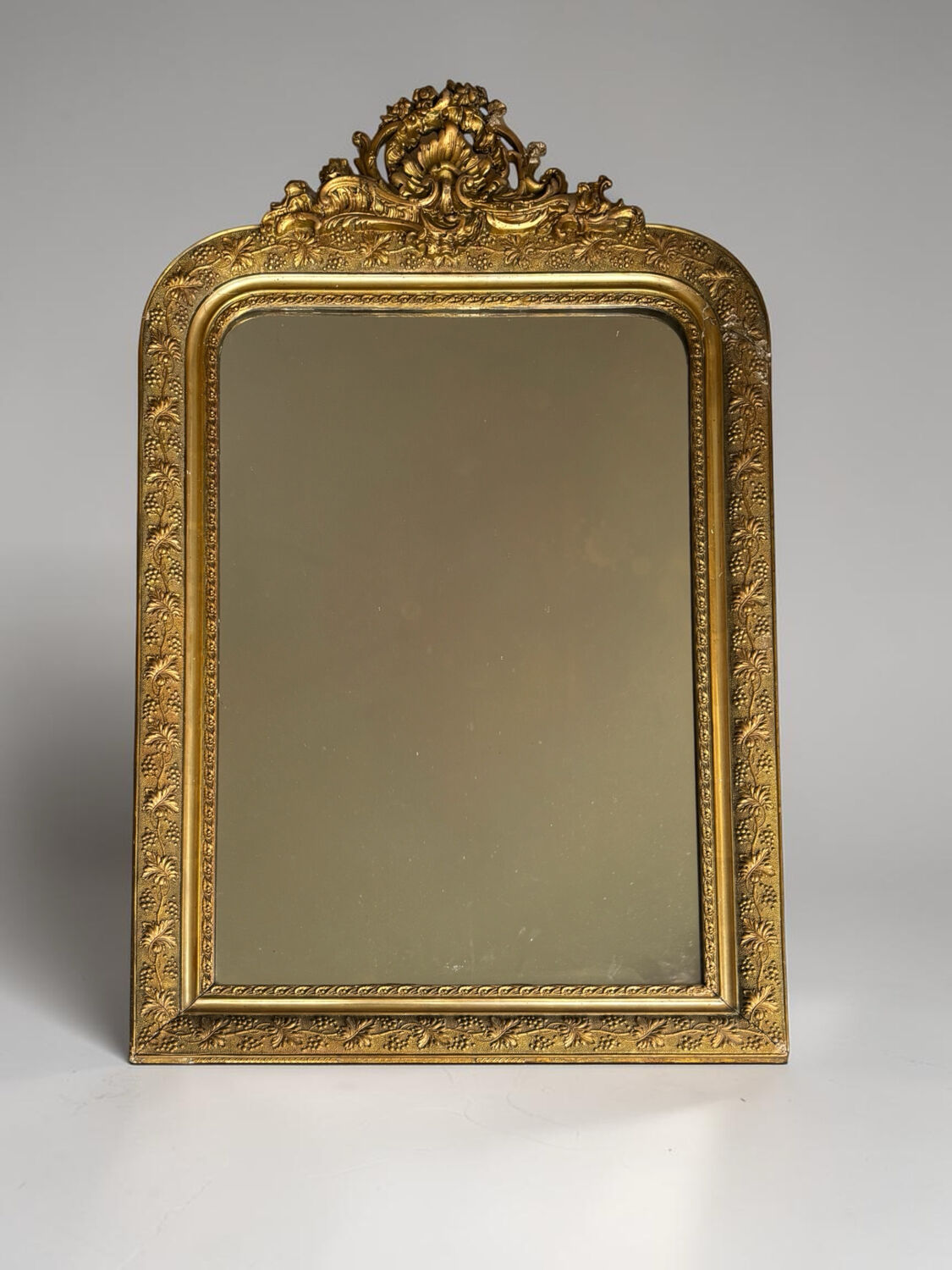 Golden mirror with a pediment from the early 20th century.