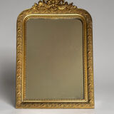 Golden mirror with a pediment from the early 20th century.