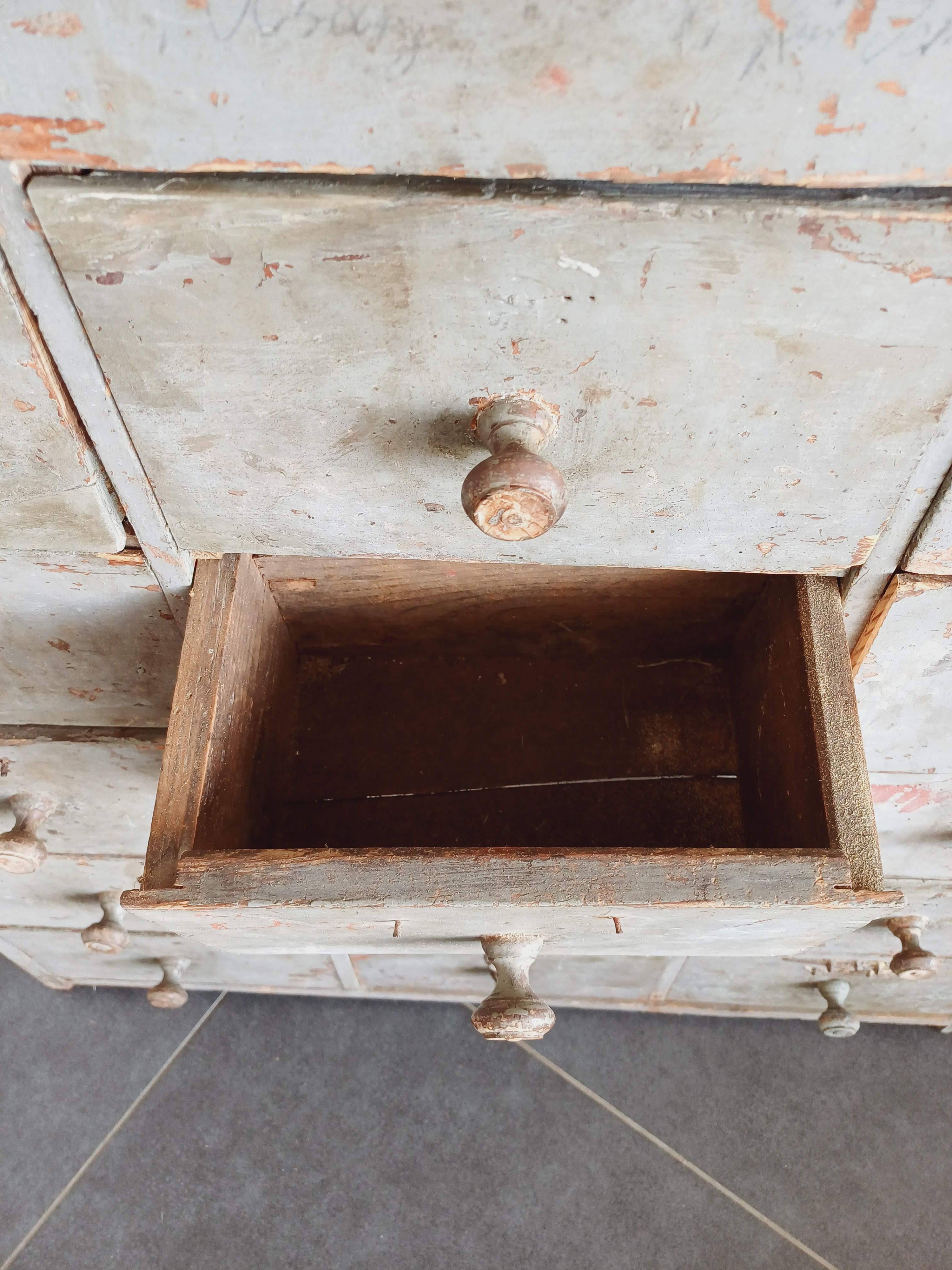 Craft cabinet with drawers with a very old tobacco advertisement in the background