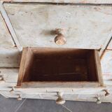 Craft cabinet with drawers with a very old tobacco advertisement in the background