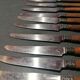 Old table knives and dessert knives, wooden handles, stainless steel blades