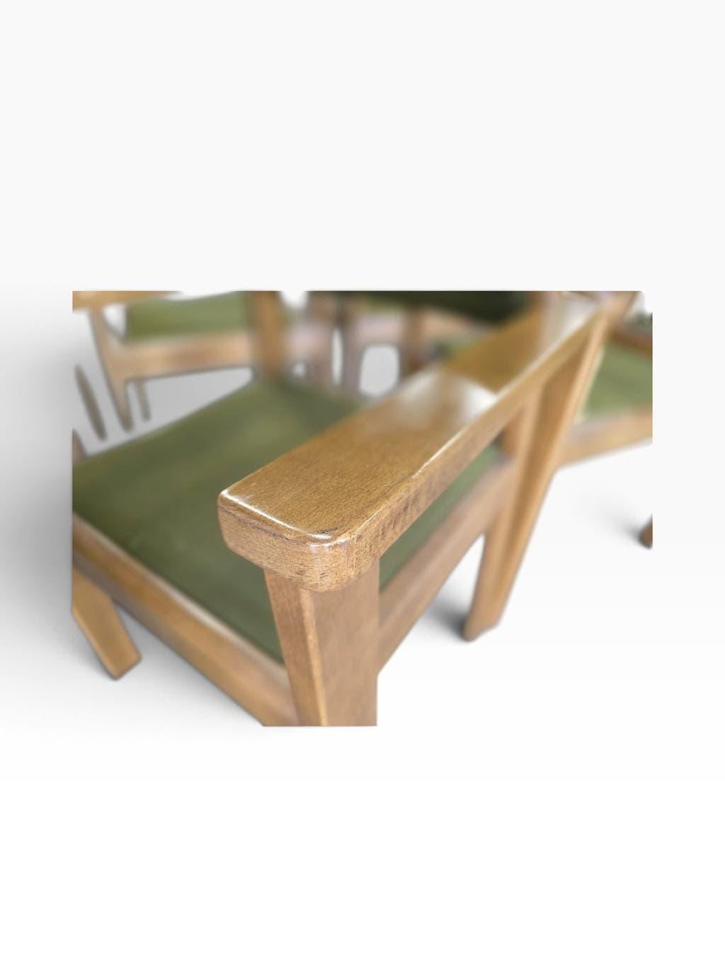 Vintage wooden chair with olive green seat and armrests.