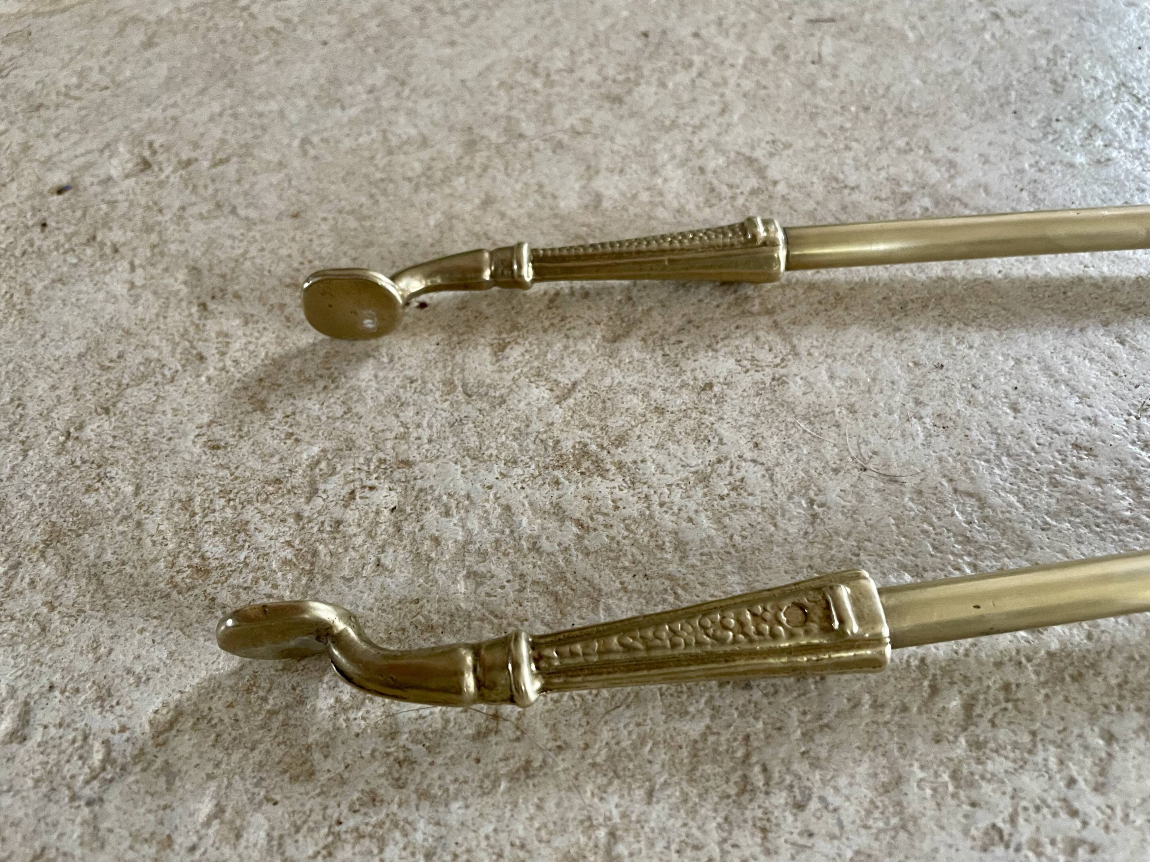 Brass fireplace tools in the style of Maison Baguès.