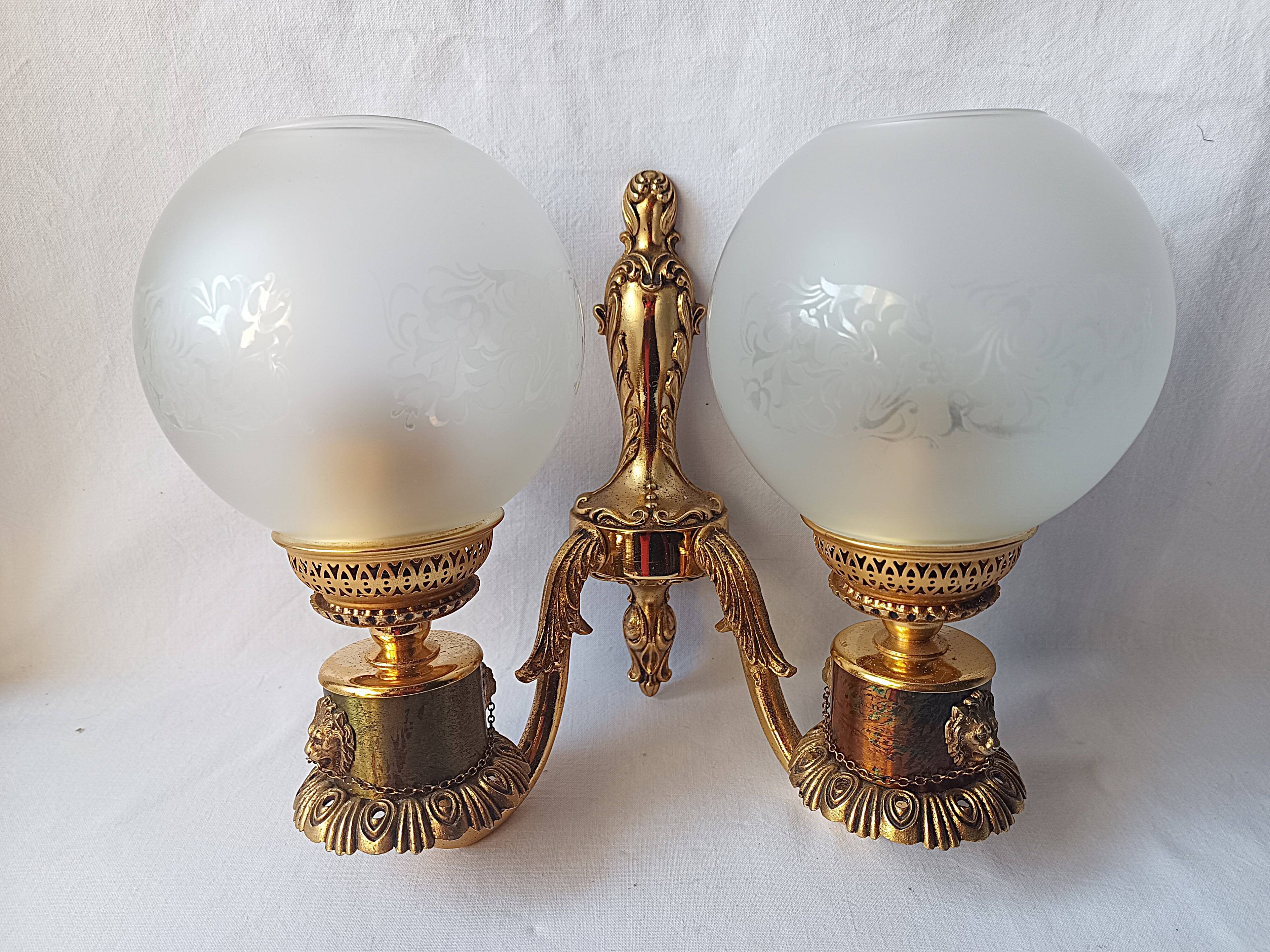 Wall lamp in gilded bronze with a lion's head and engraved globe.