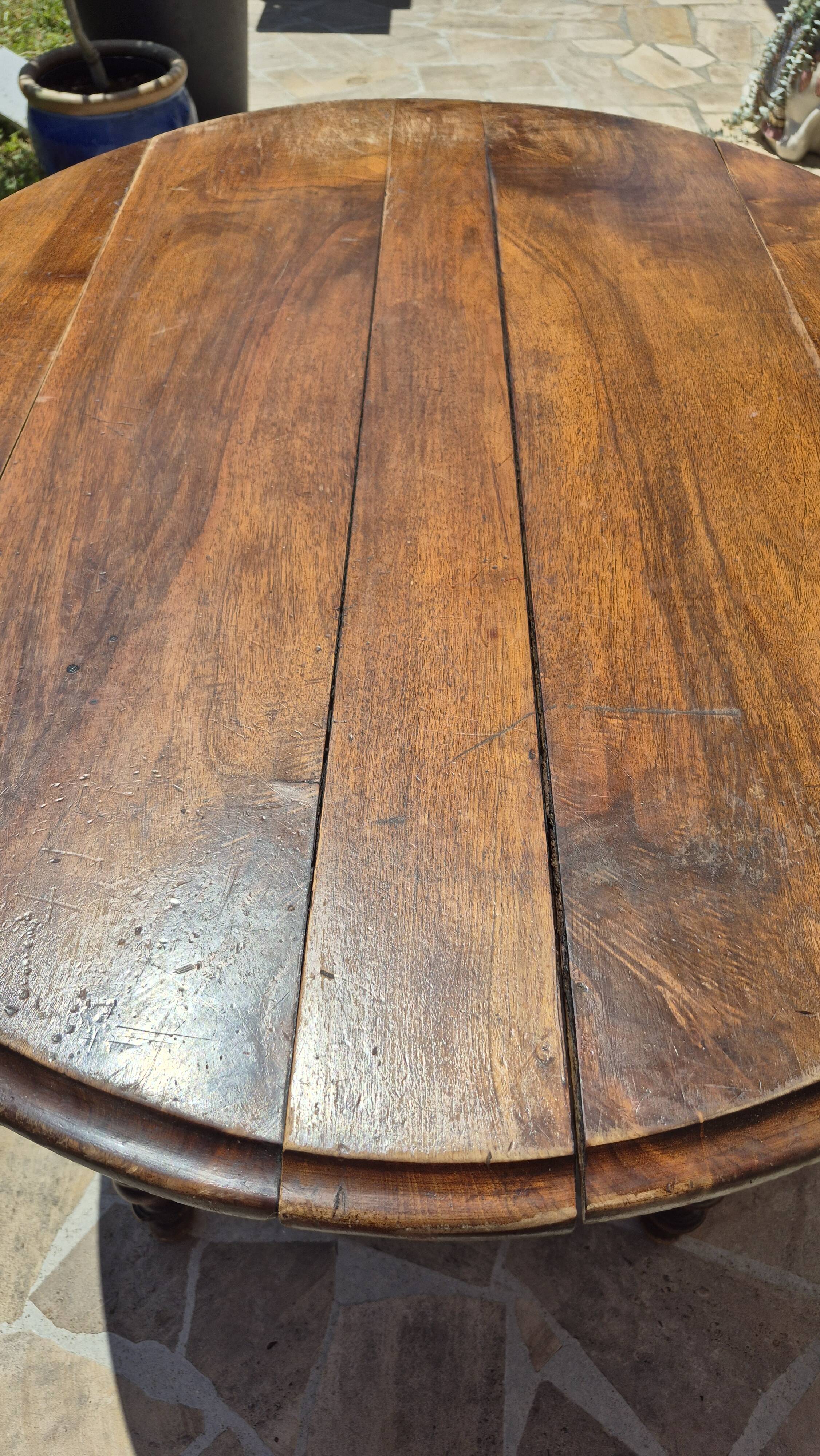 Round dining table with a drop-leaf top in solid walnut, late 19th century.