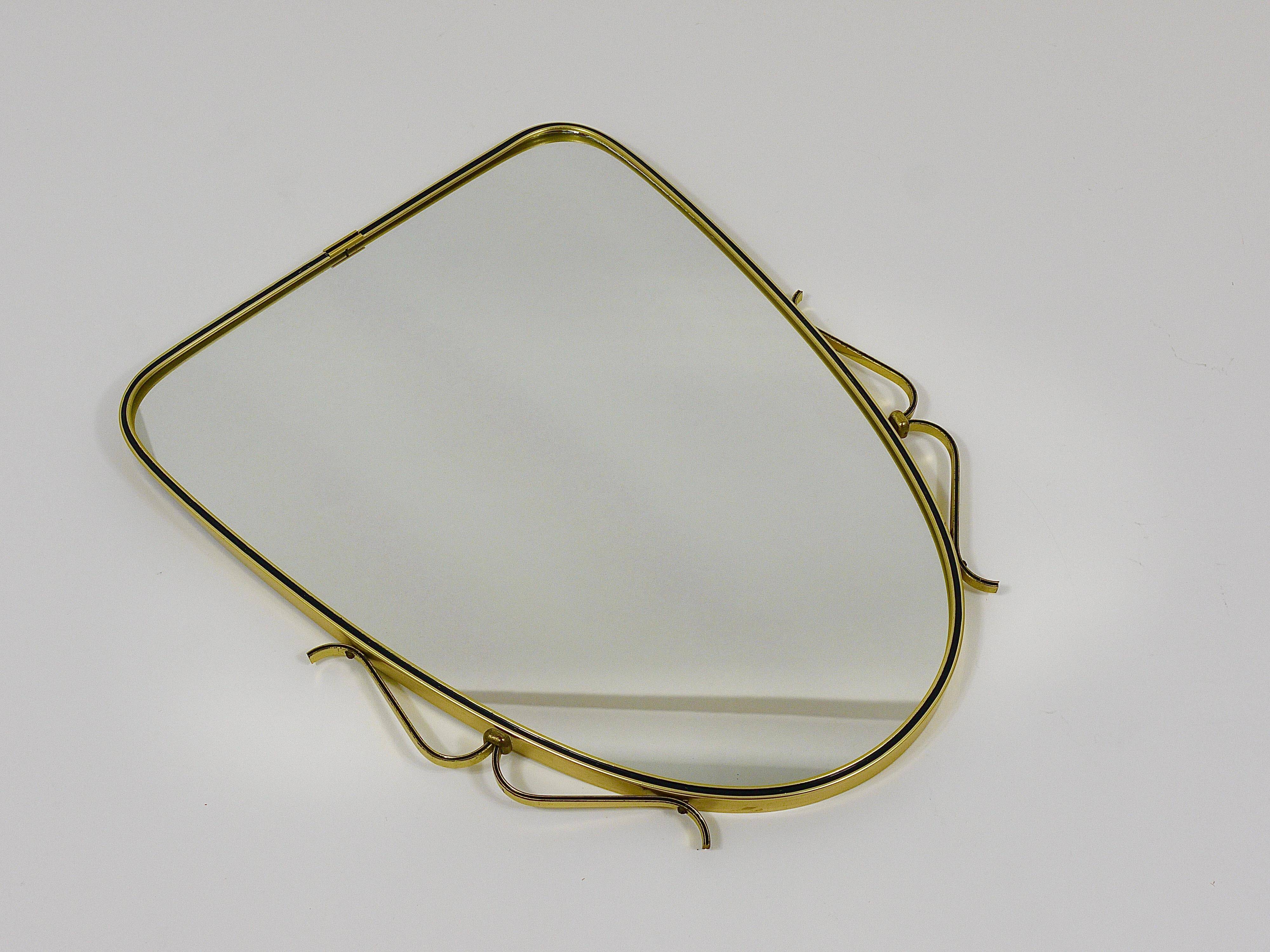 Elegant wall mirror in brass and black from the mid-century, Italy, 1950s.