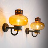 Pair of brass wall lamps with decorated amber coloured shades