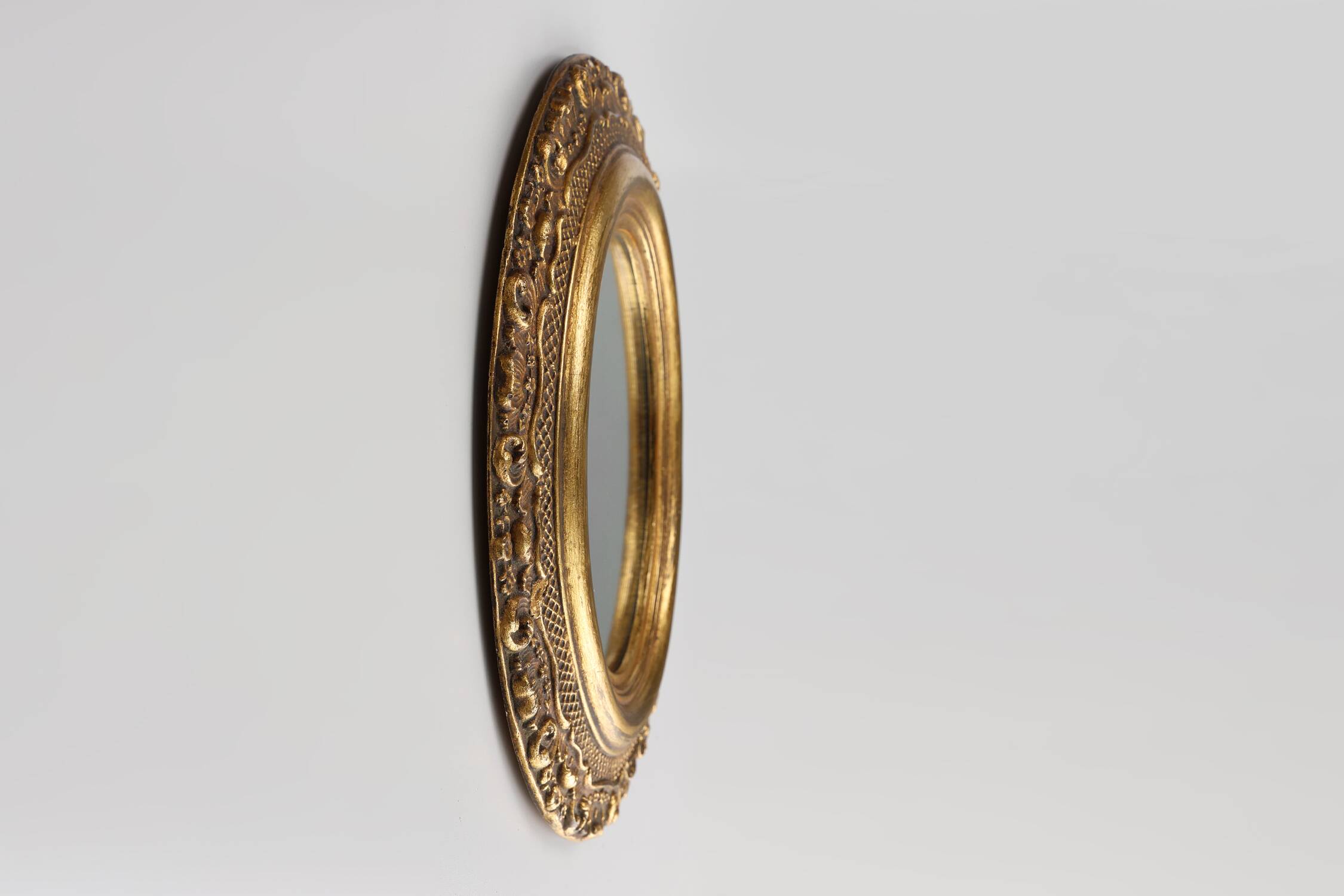 French Baroque style oval mirror in gilded wood with floral decorations