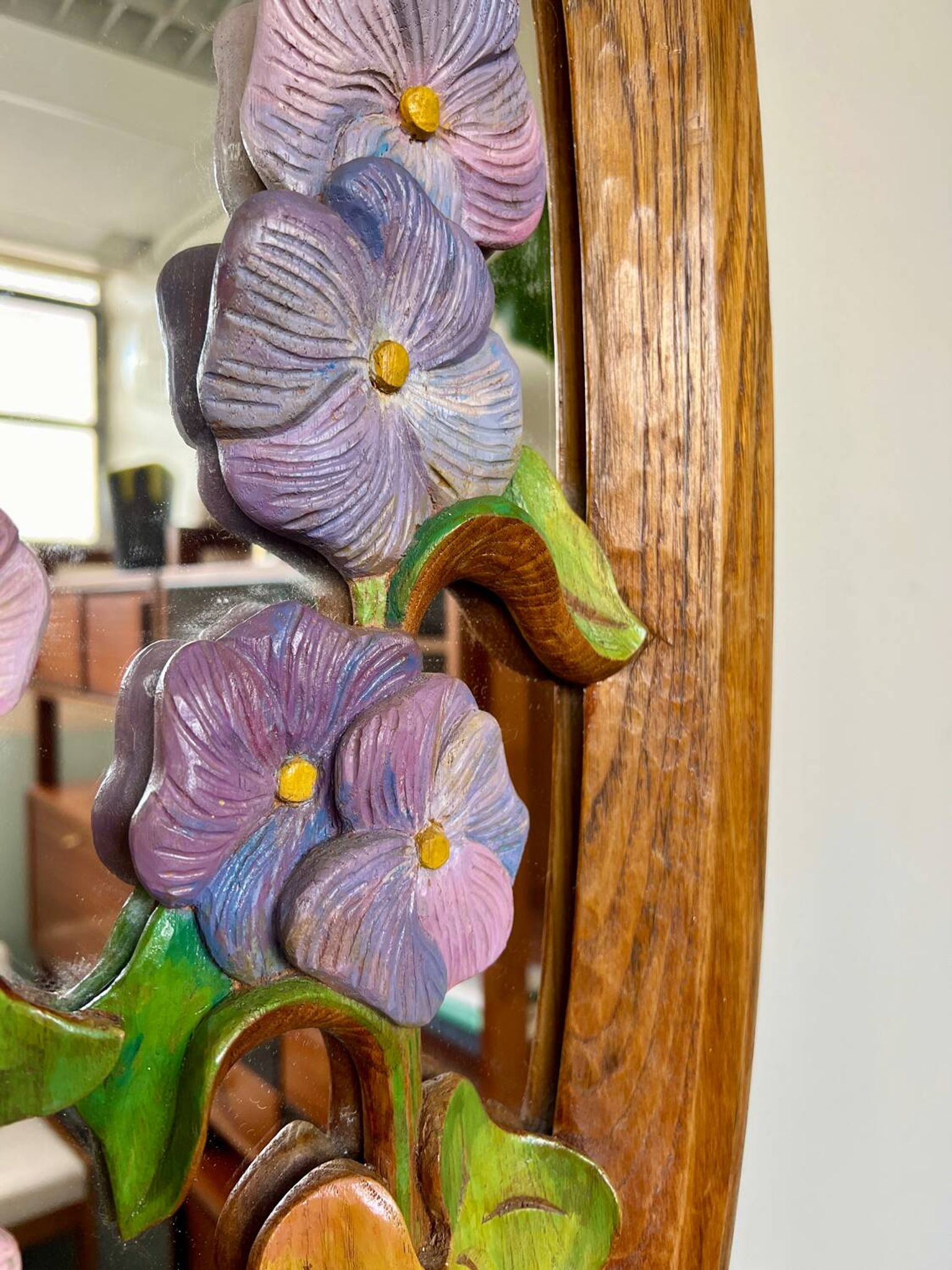 Carved wooden mirror with flower decorations.