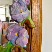 Carved wooden mirror with flower decorations.