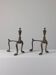 A pair of vintage brass andirons with a zoomorphic design.