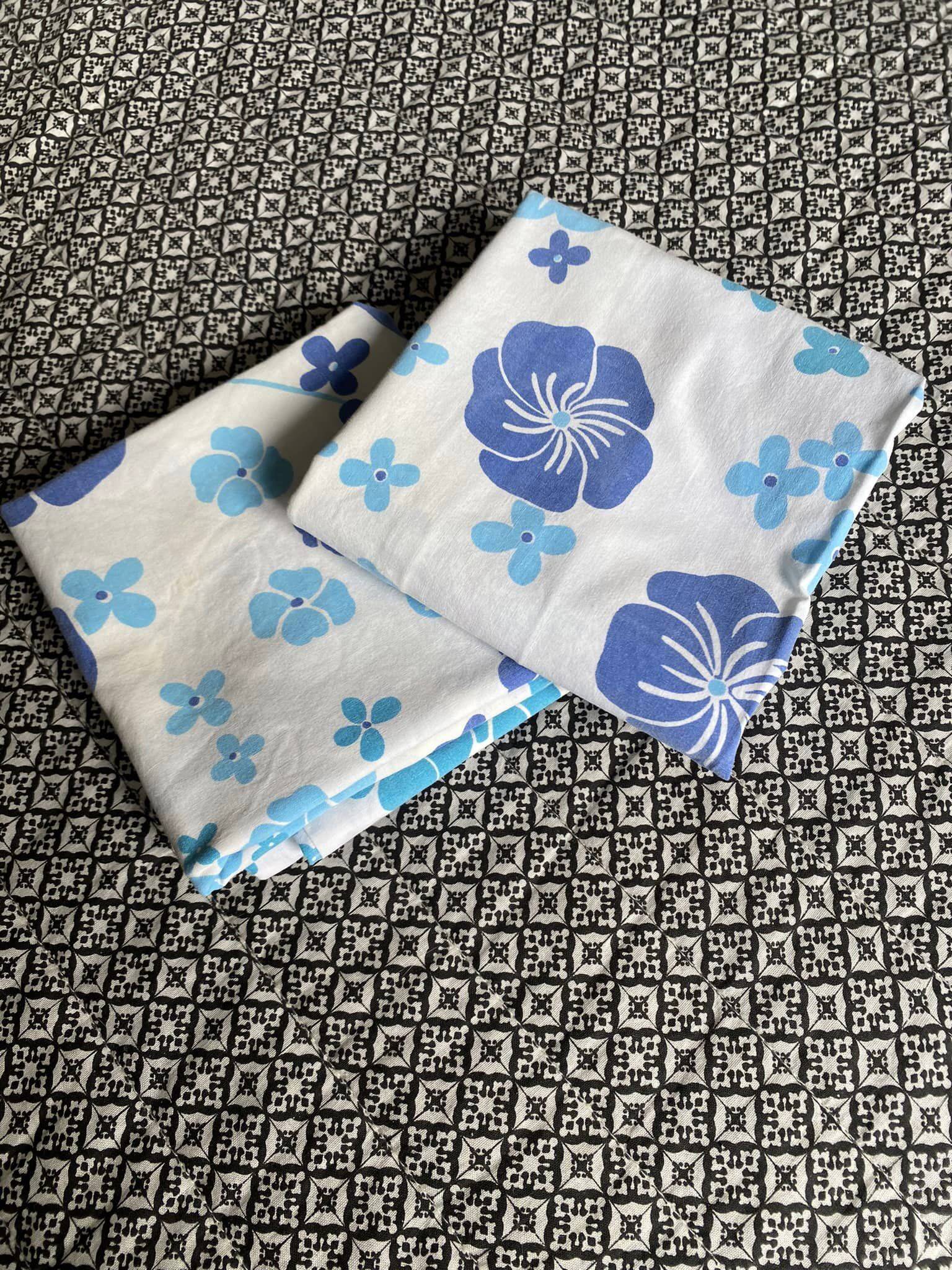 2 vintage cotton pillowcases with blue floral patterns.