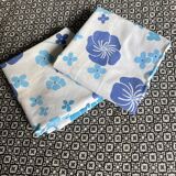 2 vintage cotton pillowcases with blue floral patterns.