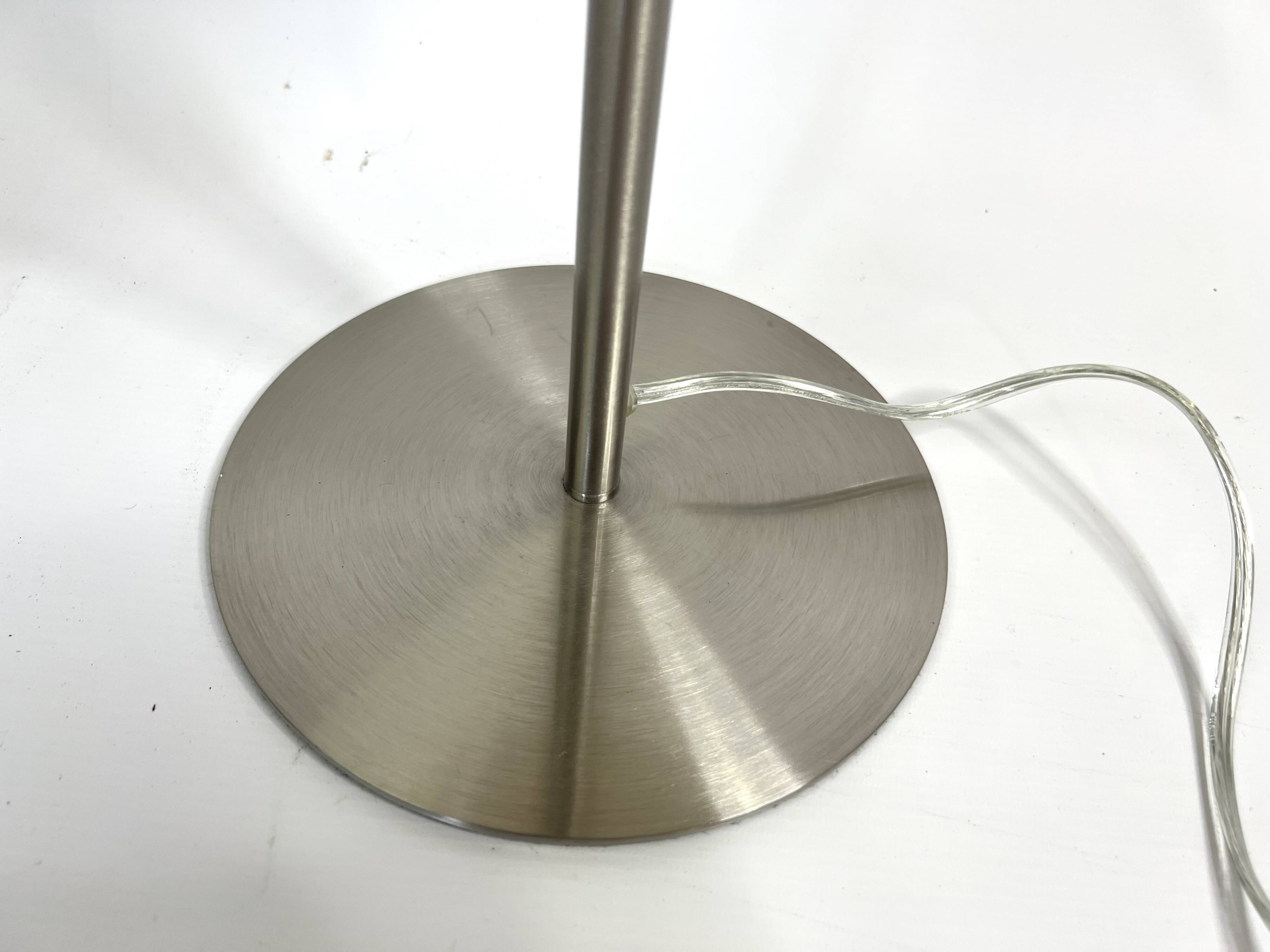 Large brushed metal table lamp with an ecru shade.