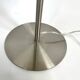 Large brushed metal table lamp with an ecru shade.