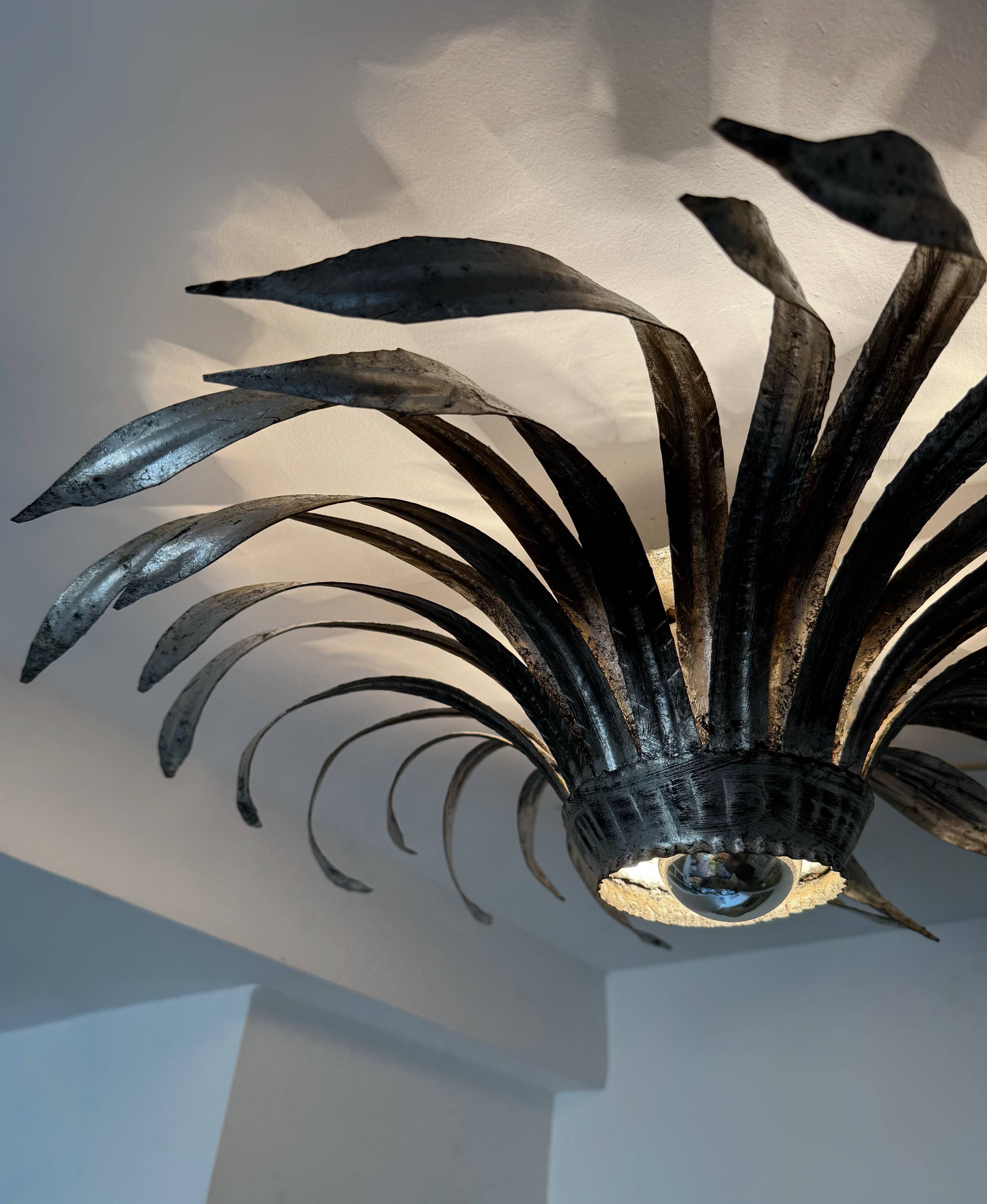 Silver wrought iron sunburst wall light from the 1960s.