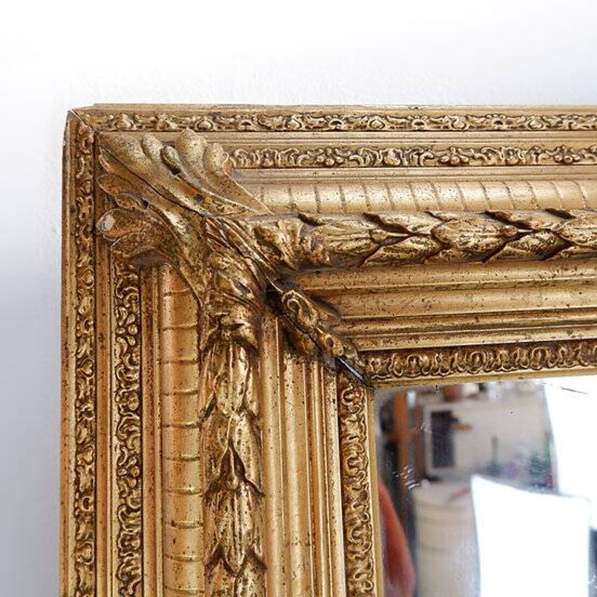 Large gilded wood and stucco mirror with foliage