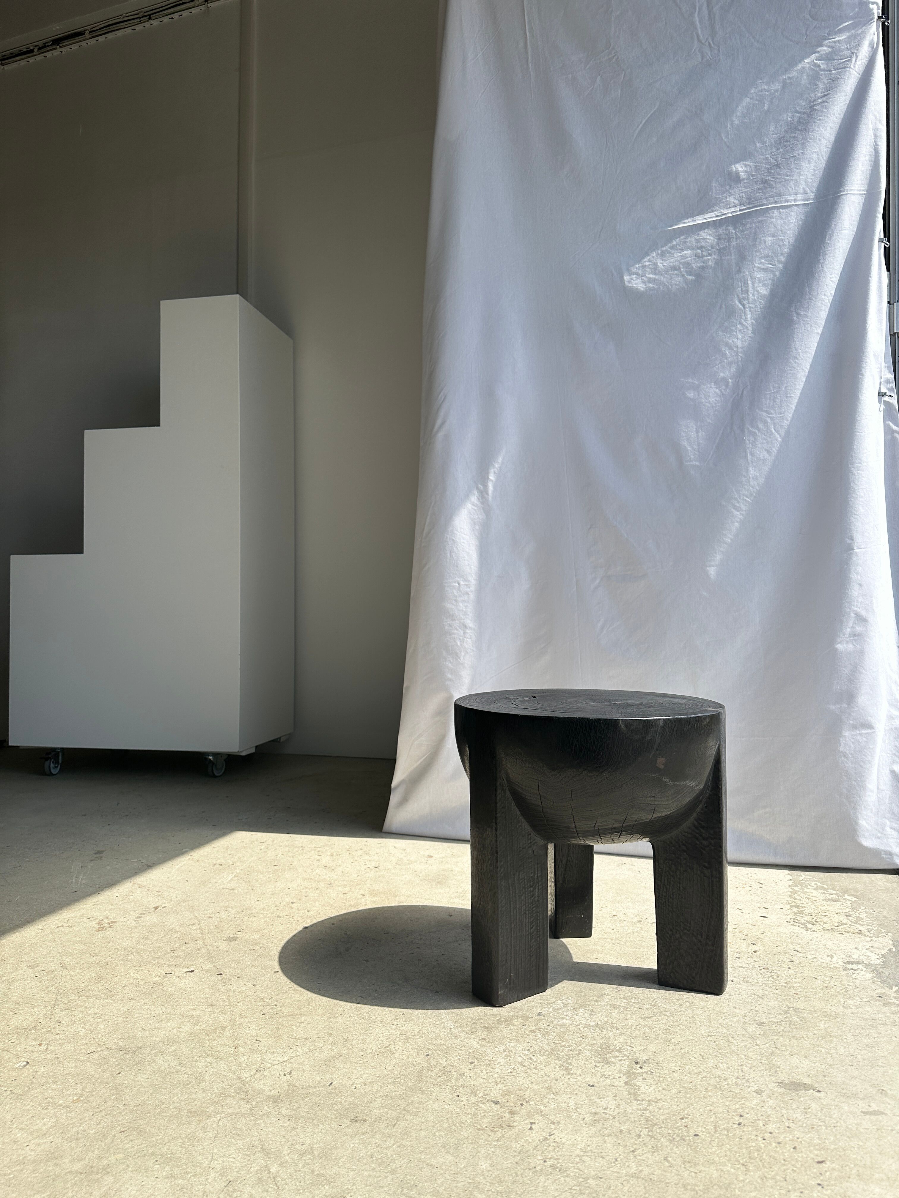 Black mango wood tripod side table with a semi-spherical top, height: 45 cm, diameter: 44 cm.