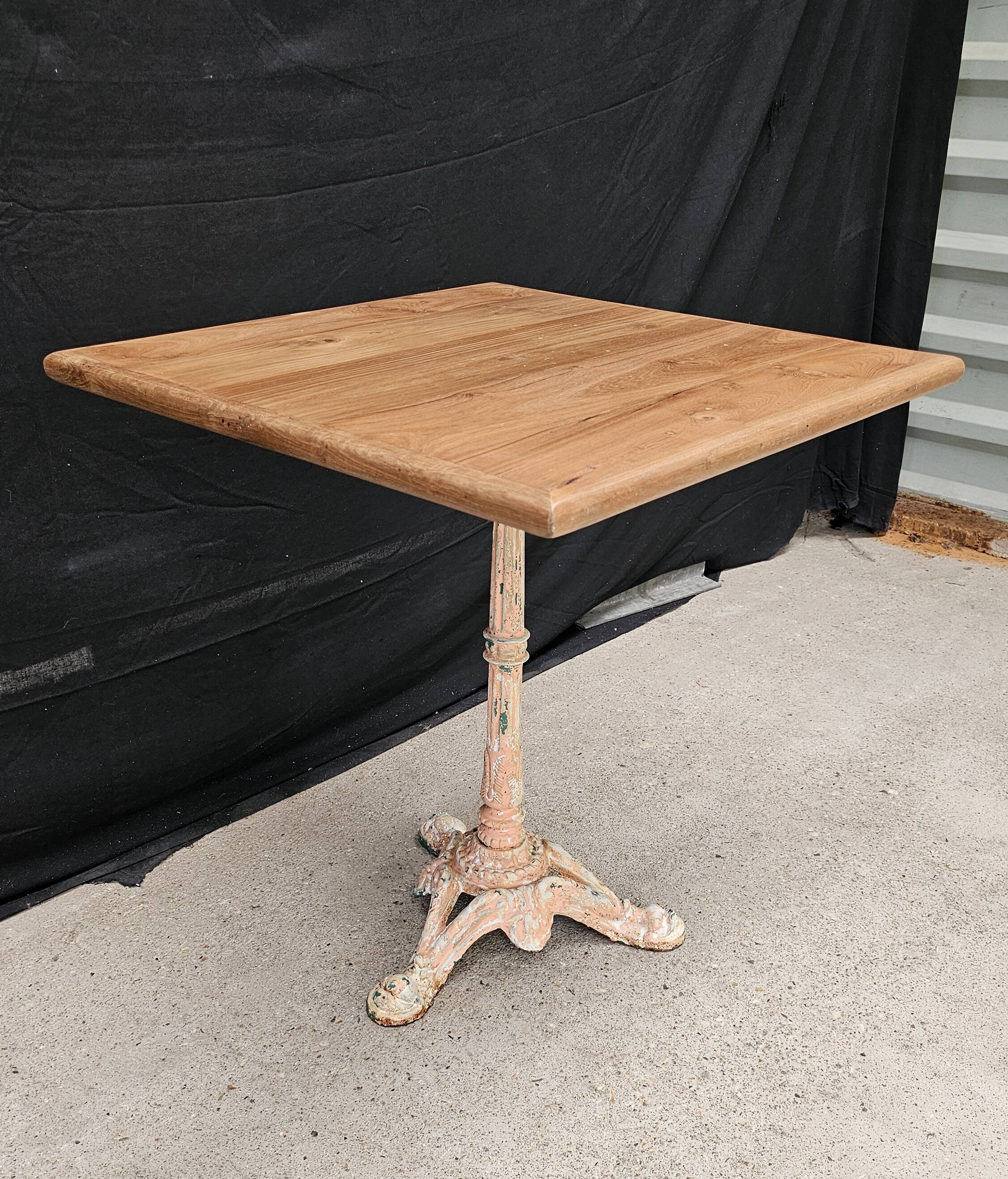 Bistro table with cast iron base and solid teak top