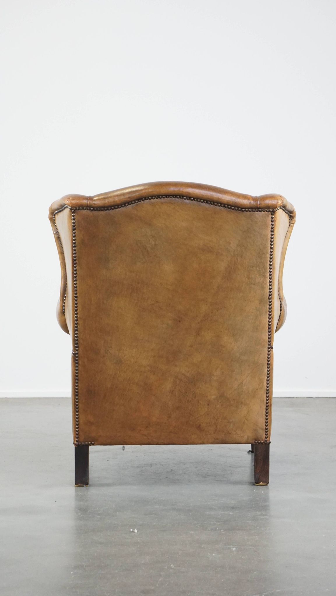 Patinated sheep leather wingback armchair