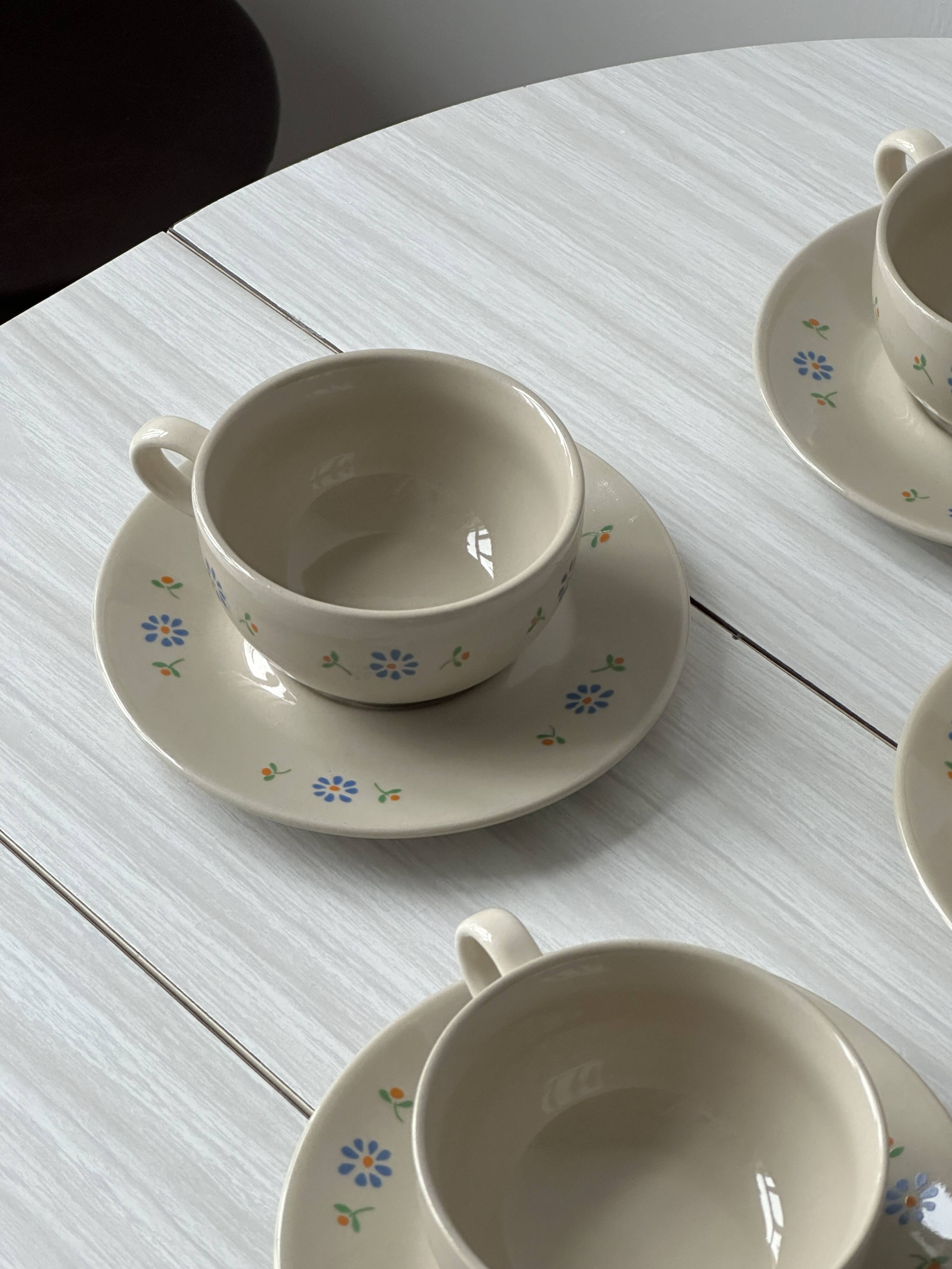 Ceramic cups and saucers with flower decoration