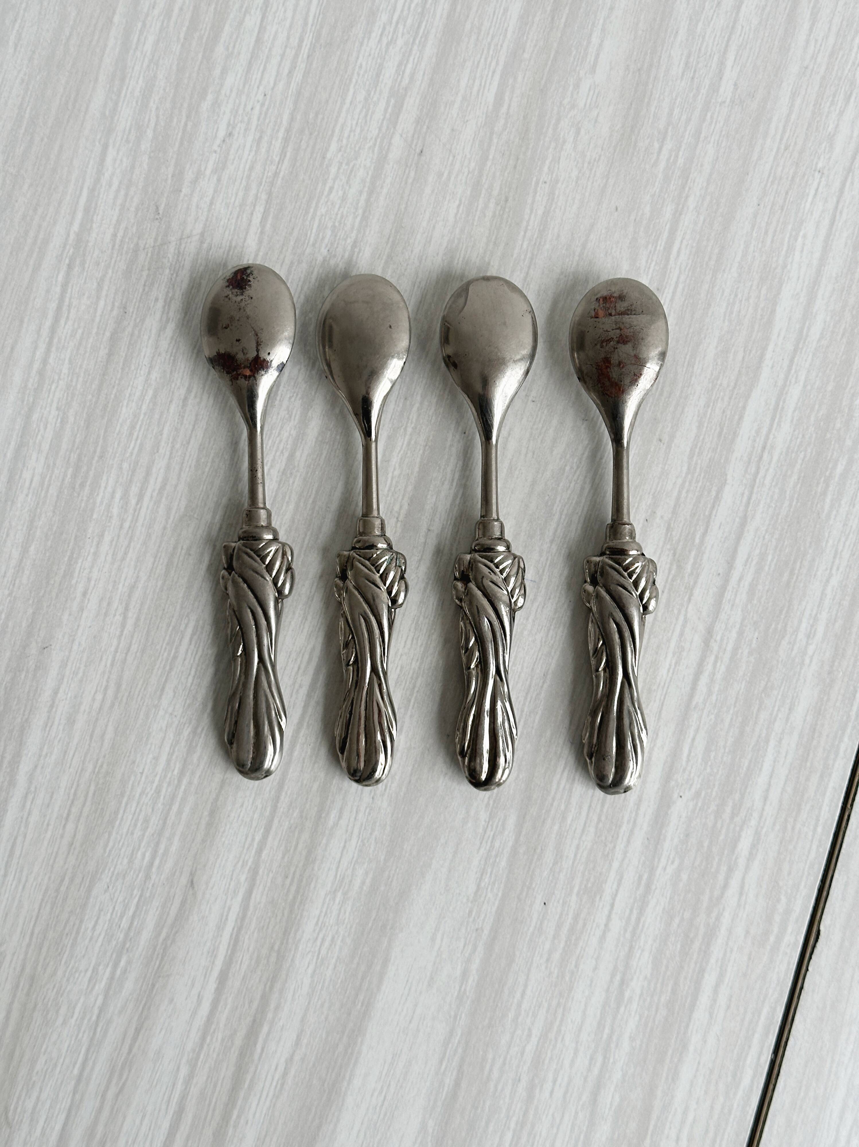 Antique small spoons with a metal bow design