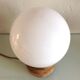 Lampe globe en opaline blanche sur socle bois