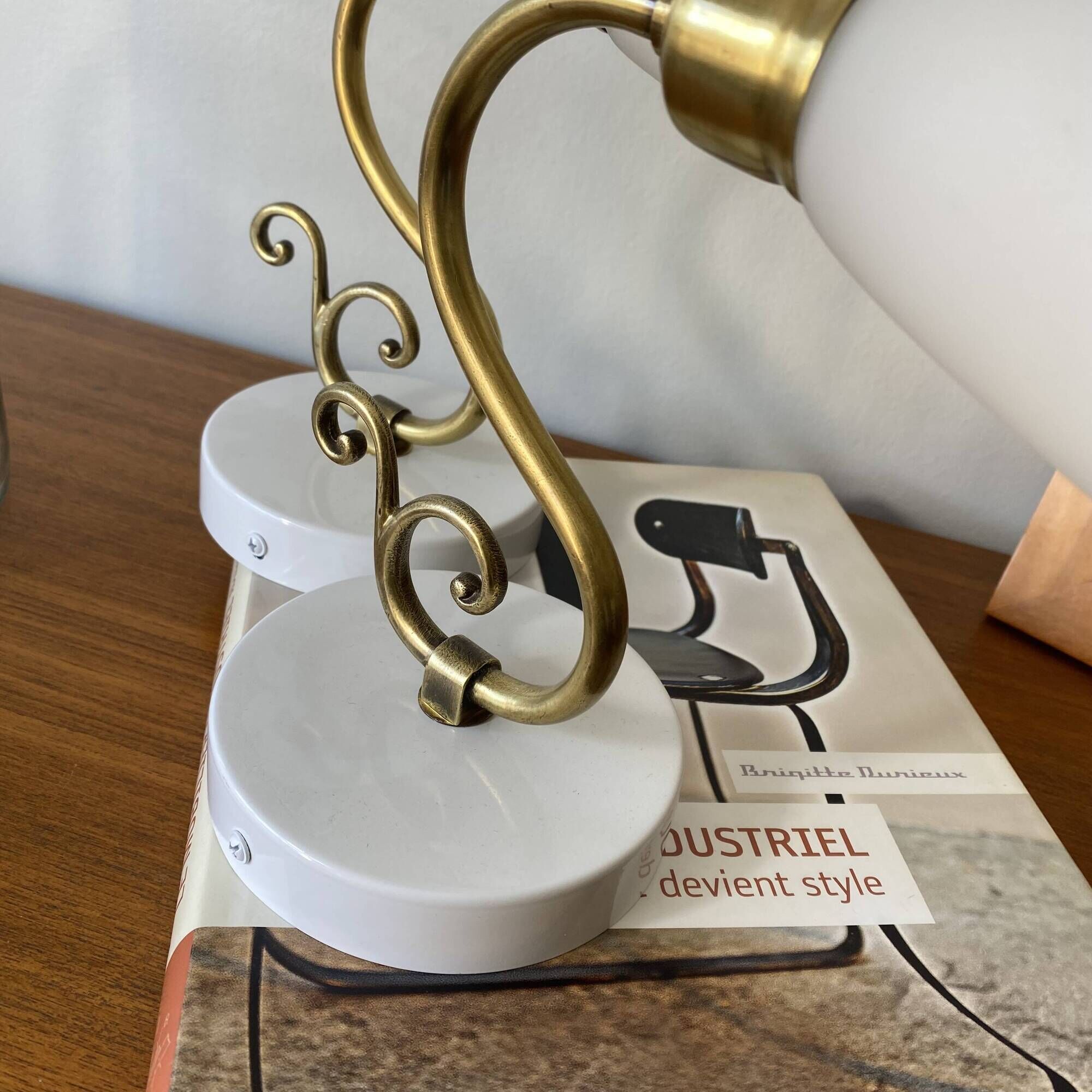 Pair of brass swan neck wall lights with white glass shades.