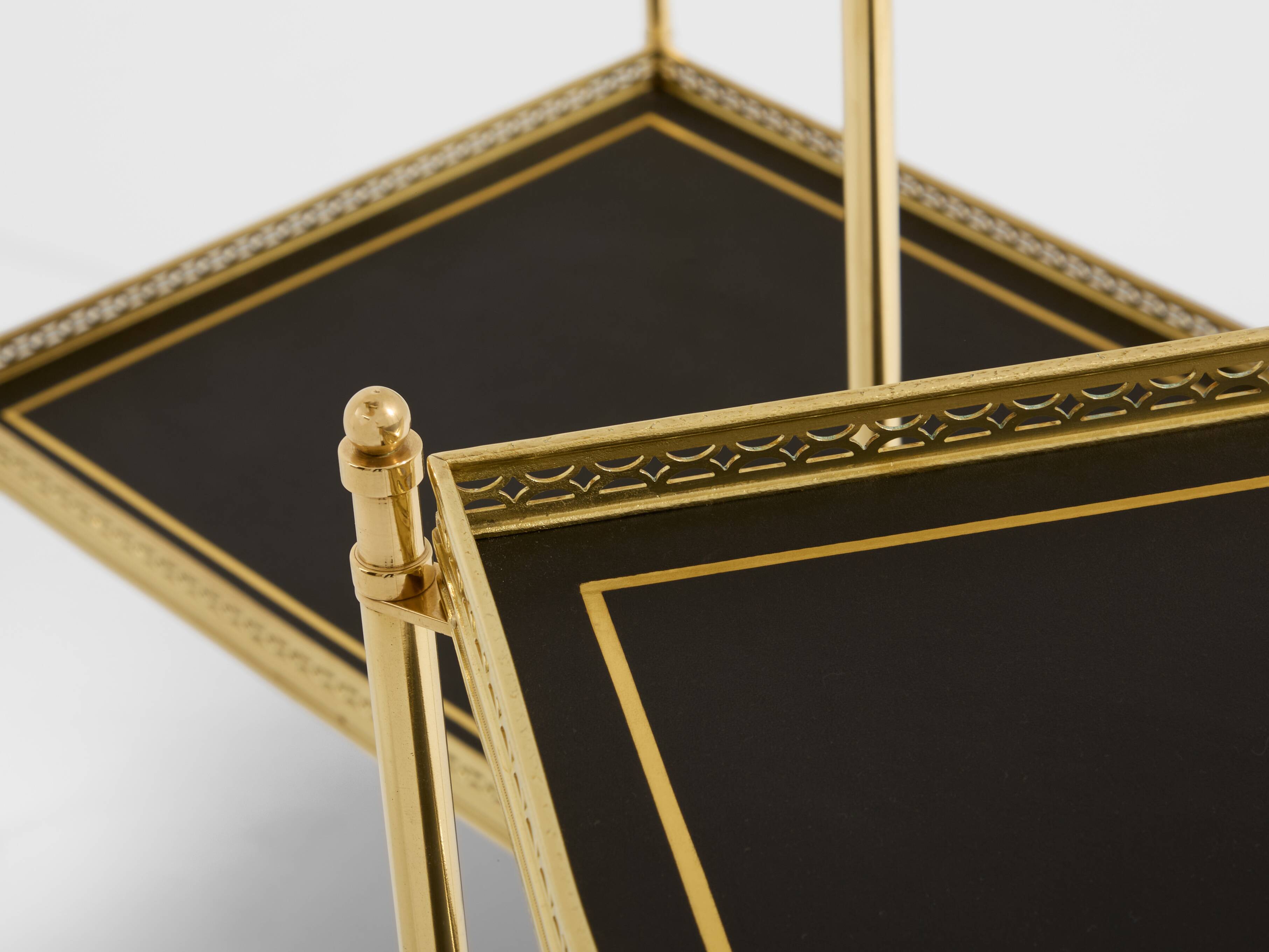 Pair of neoclassical side tables in brass and black leather by Maison Jansen, 1960.