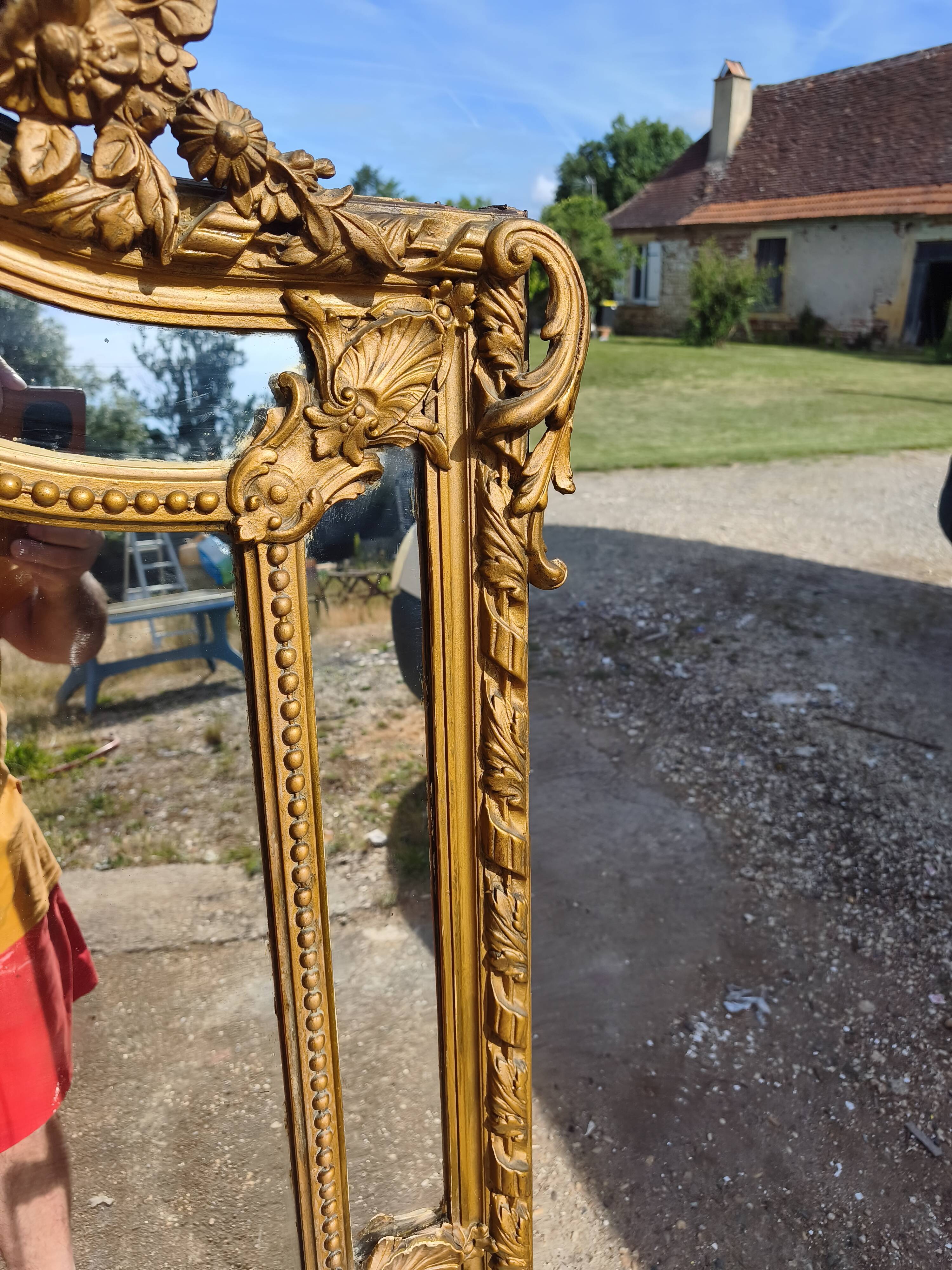 Large closed mirror, 19th century, wood and gilded stucco.