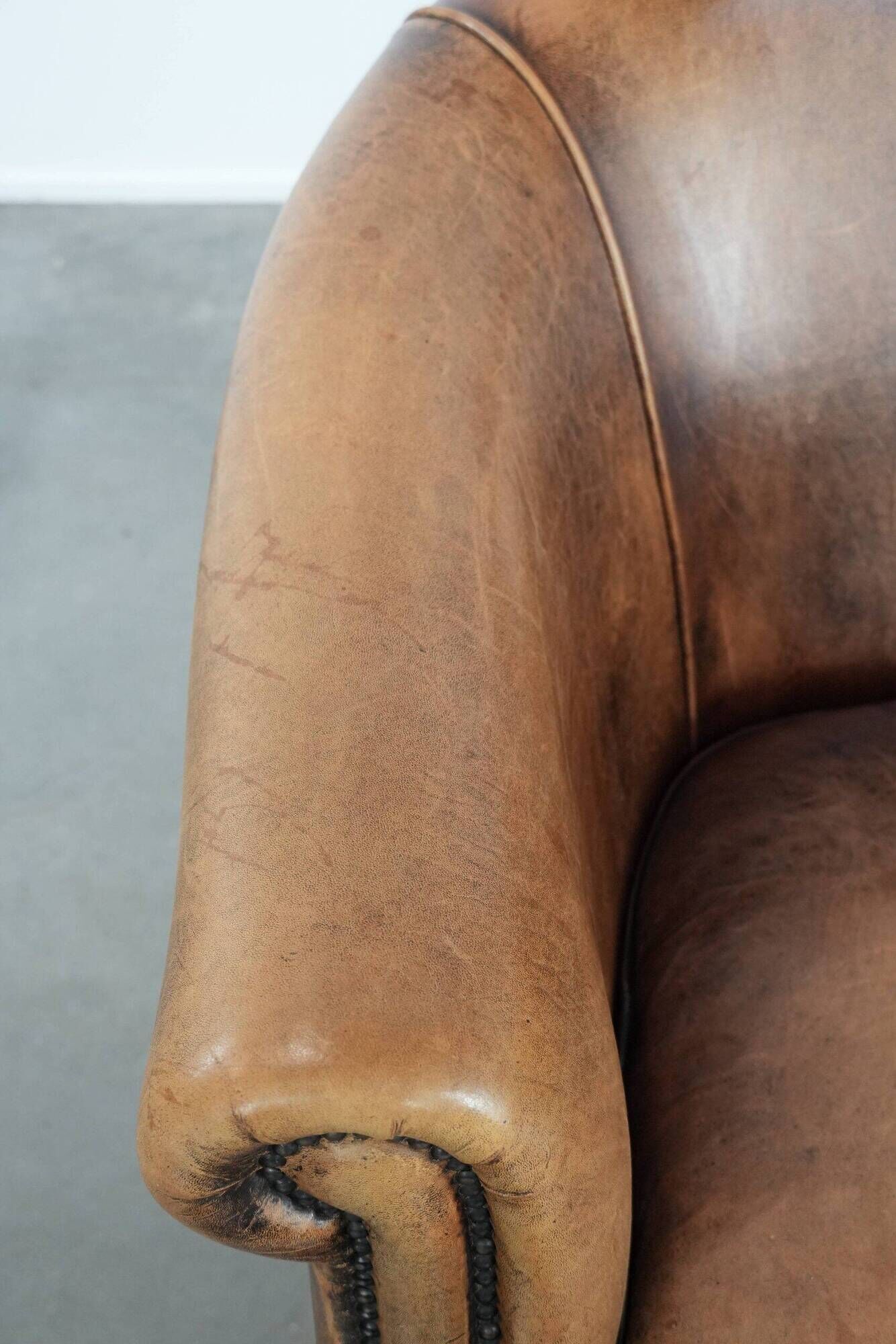 Club chair made of sheepskin leather finished with decorative nails