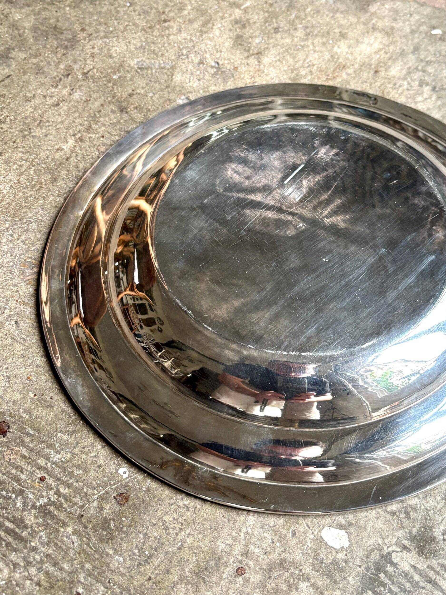 Round, hollow silver-plated metal dish