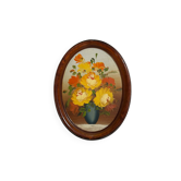 Painting of flowers in an oval frame.