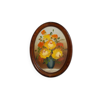 Painting of flowers in an oval frame.