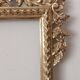 Mirror with a carved wooden frame in an antique style in pure gold.