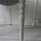 Walnut table with raised flaps, base on verdigris casters.
