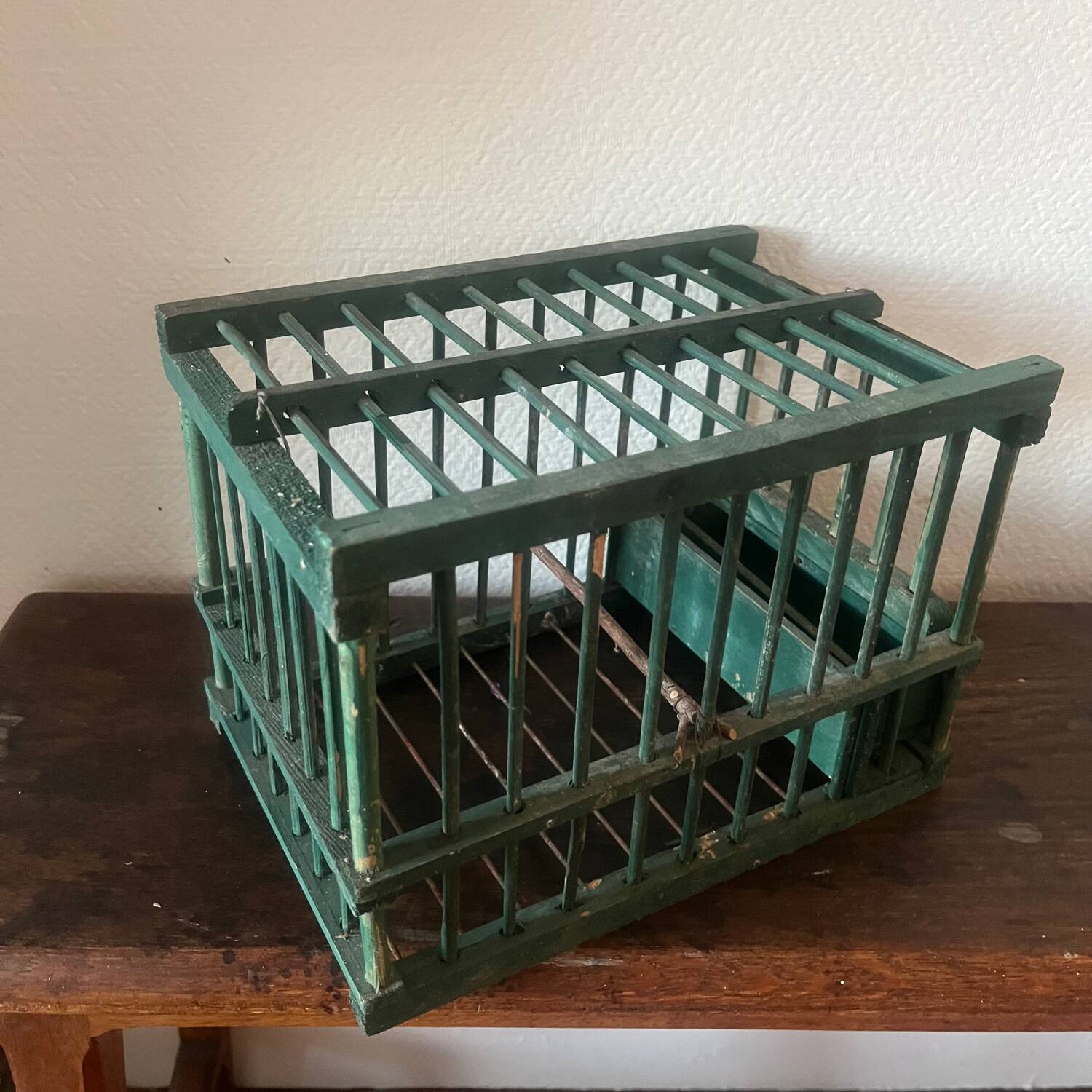 old bird cage made of wood and painted green