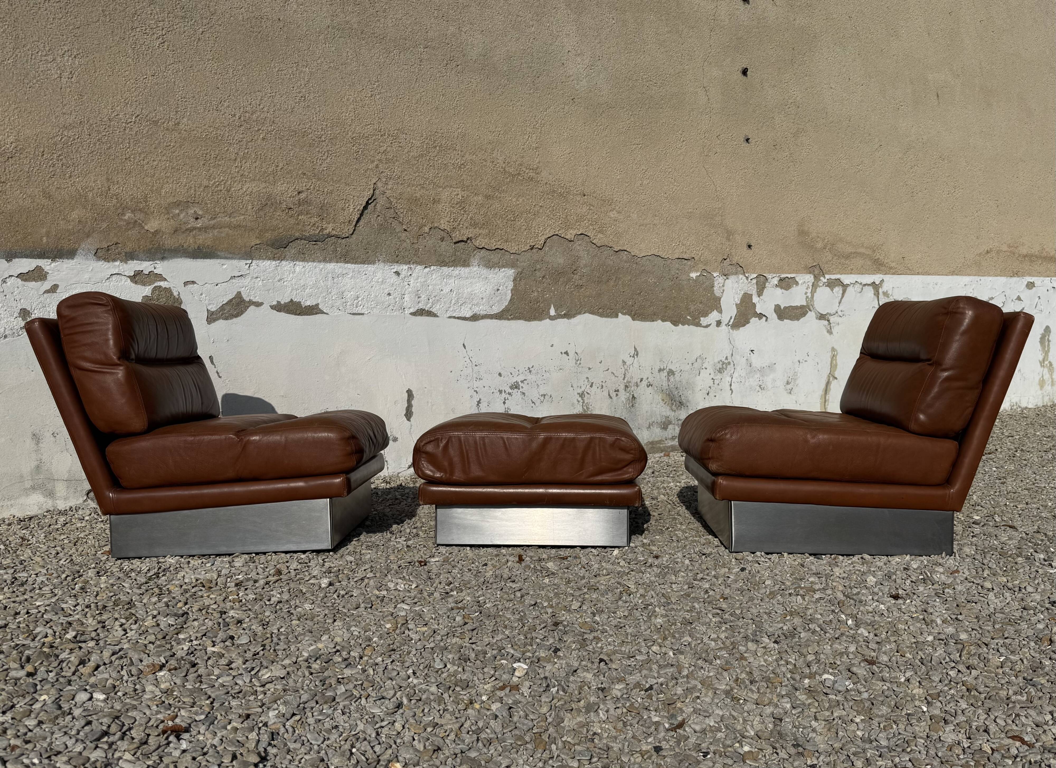 2 armchairs and 1 ottoman in brushed aluminium and brown leather, France, 1970.