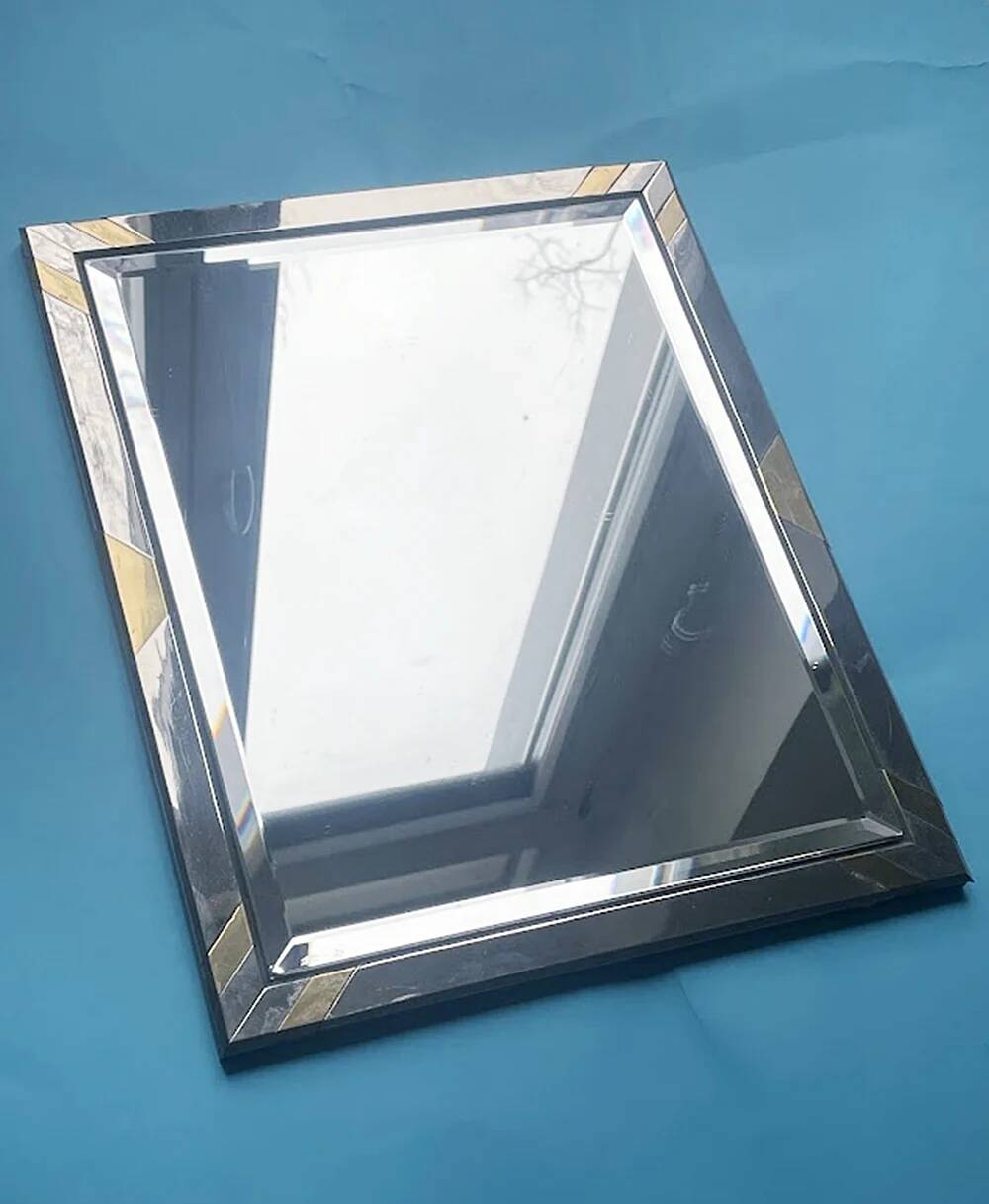 Faceted modernist wall mirror in steel and brass, geometric mixed metal frame 1970s.