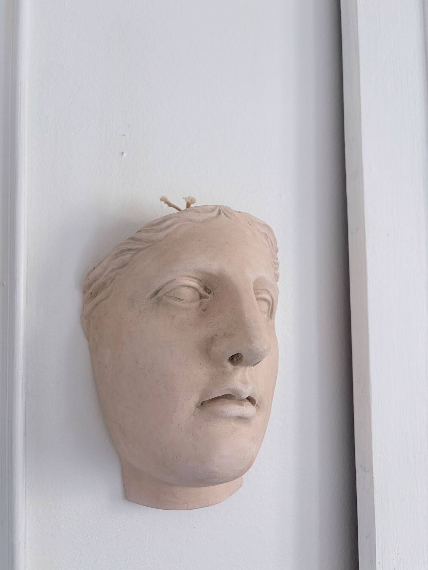 Wall sculpture of the face of the Venus de Milo in plaster.