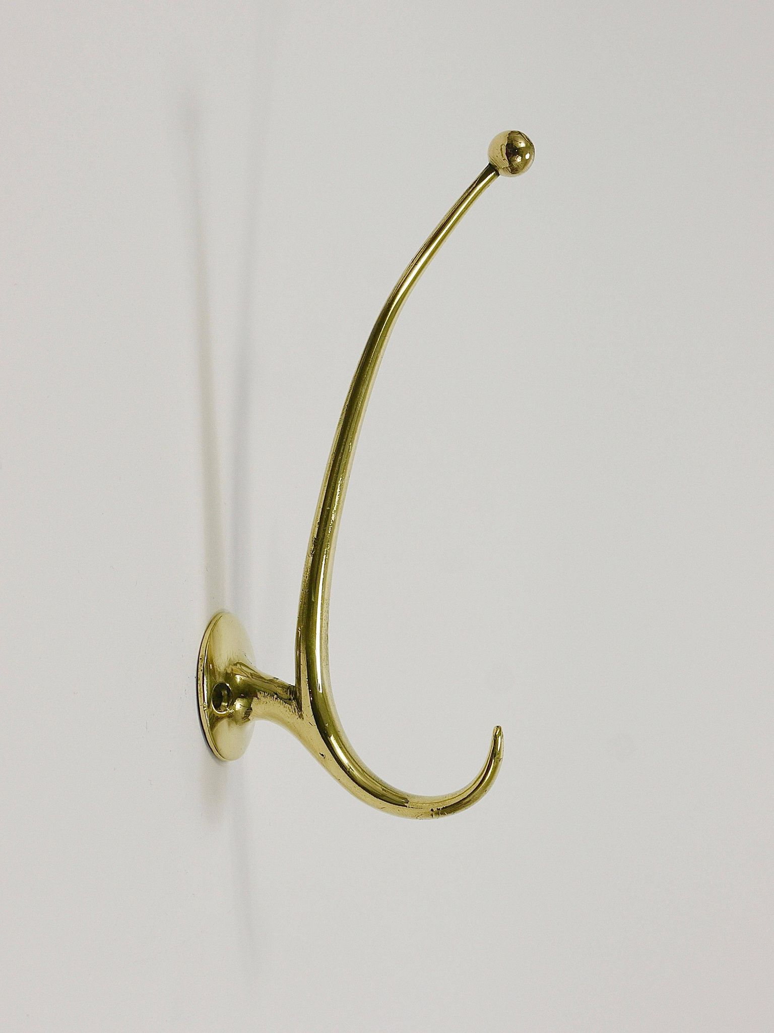 Two curved wall coat racks in brass by Franz Hagenauer, Vienna, mid-20th century, 1950s.