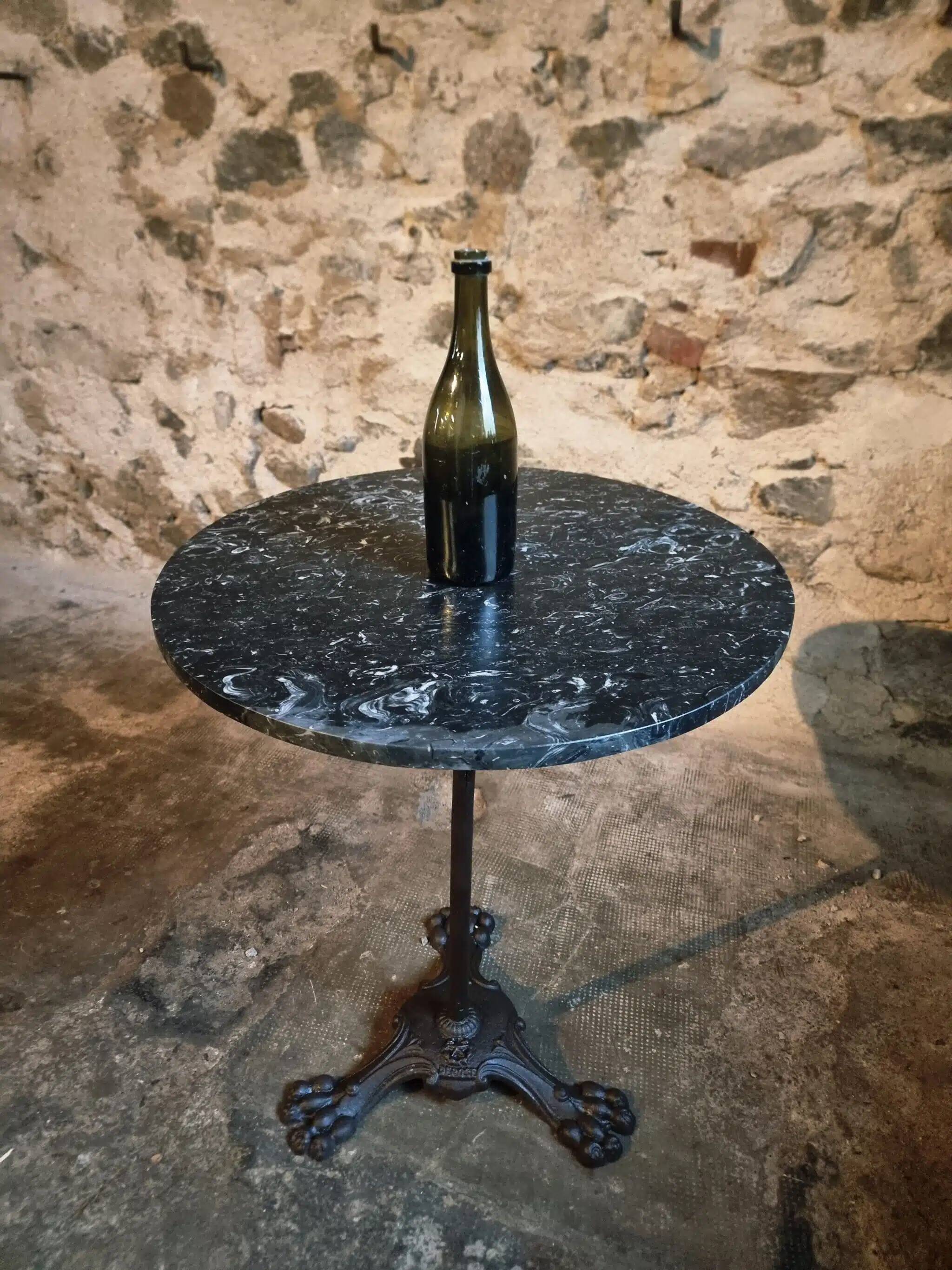 Old French bistro table with a marble top and a cast iron base.