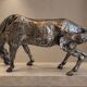 Sculpture of a grazing horse with a silver finish.