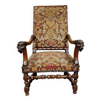 Renaissance armchair in carved walnut decorated with lion heads on the armrests, 19th century
