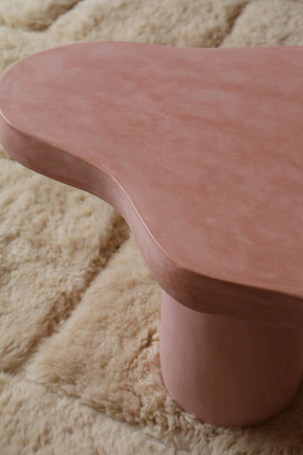 Organic shaped coffee table in pink teracotta tadelakt