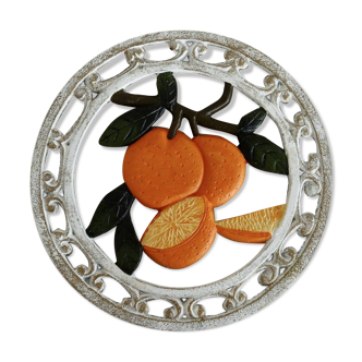 Vintage cast iron trivet with white and orange decor