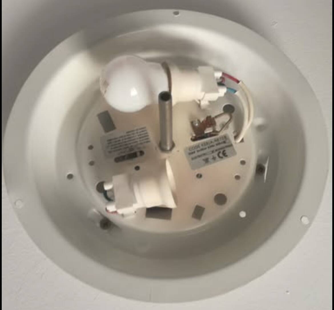 Round ceiling light with a wrought iron frame.