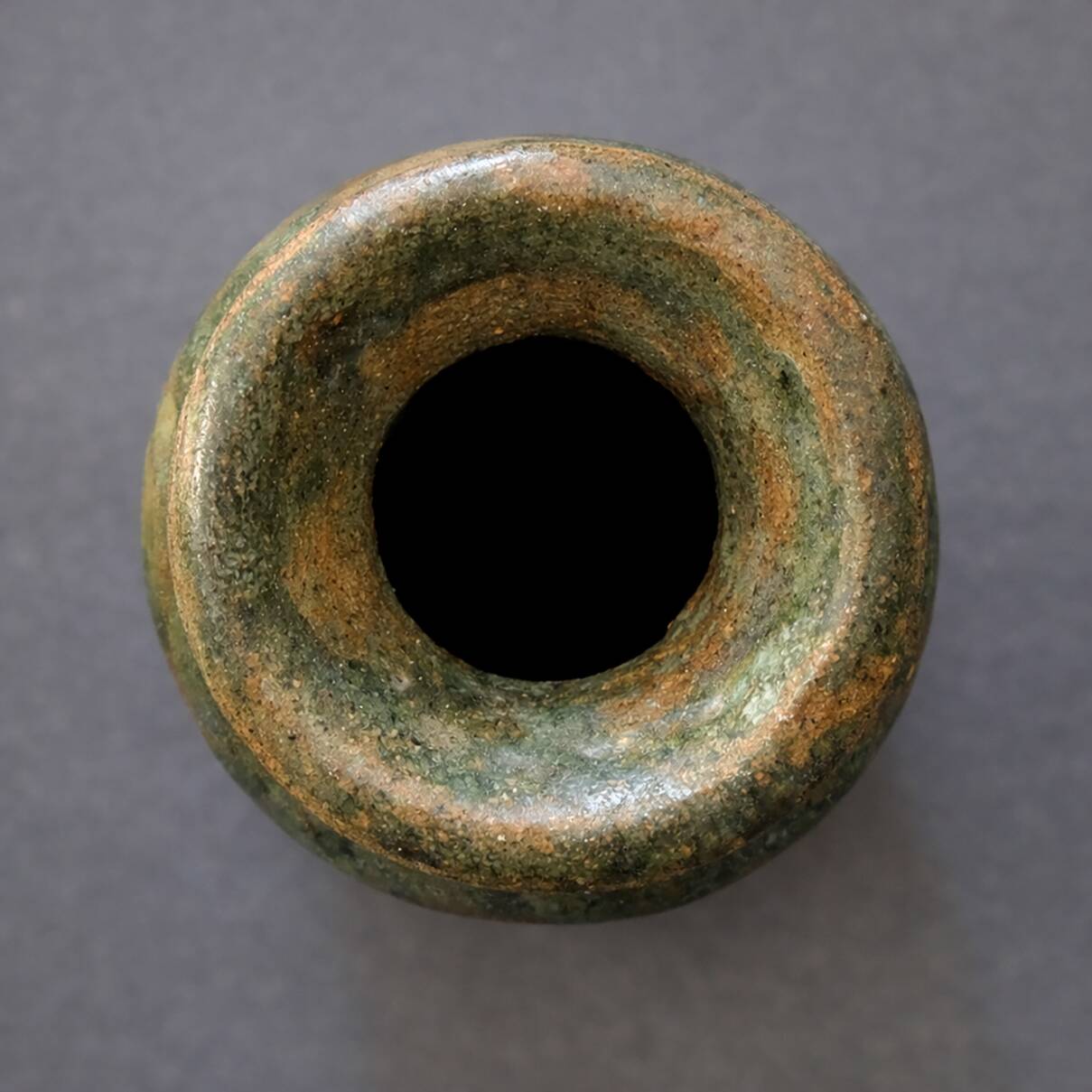 Wabi-sabi artisanal stoneware vase in green and earth tones.