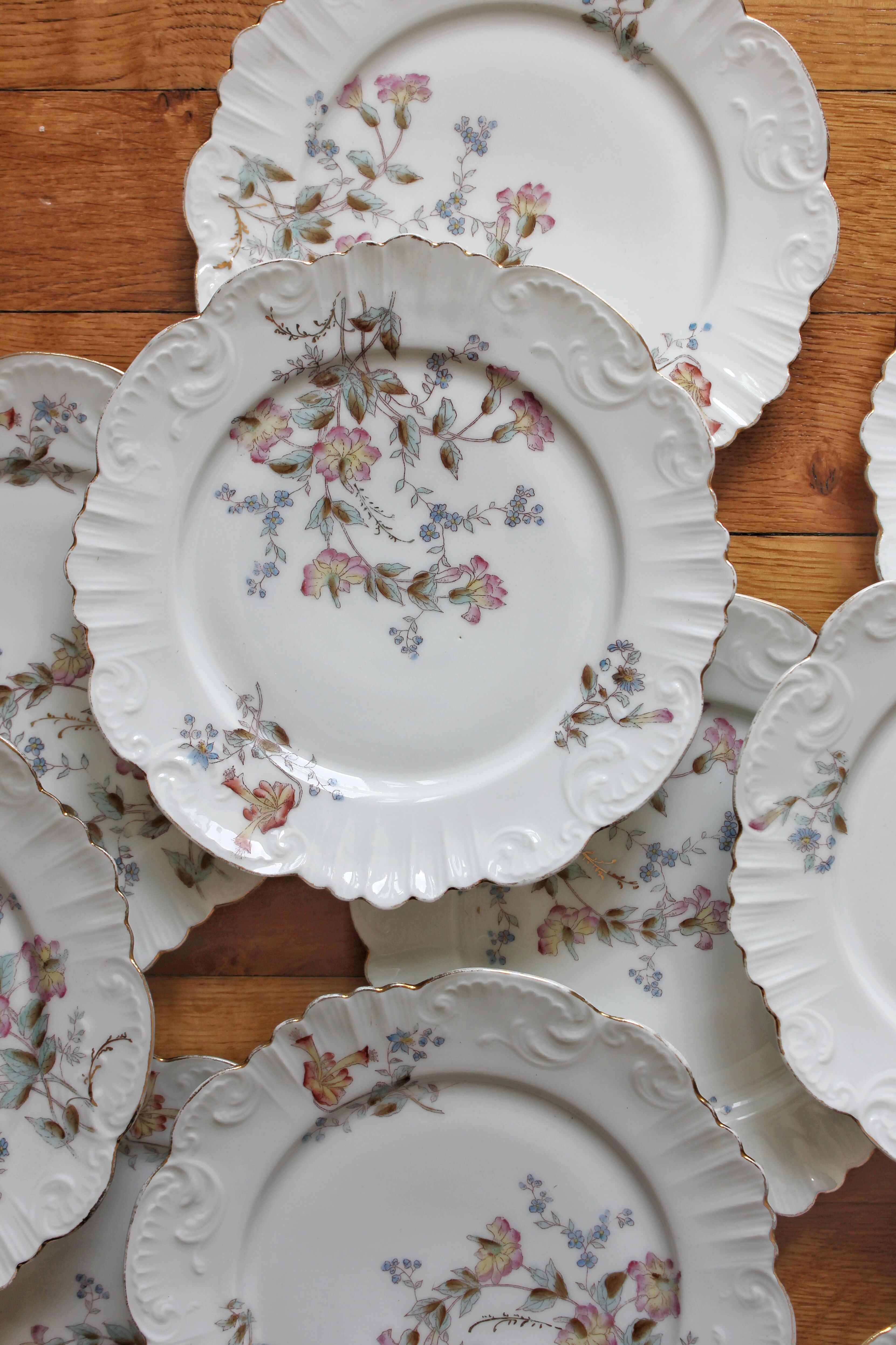 12 assiettes à dessert en porcelaine ancienne décor polychrome floral début XXe